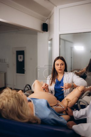 Foto de El maestro conduce una sesión práctica para los estudiantes de obstetras y ginecólogos - Imagen libre de derechos