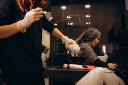 El primer plano del estilista que prepara el tinte para el cabello en el contenedor. concepto de salón de peluquería. Foto de alta calidad