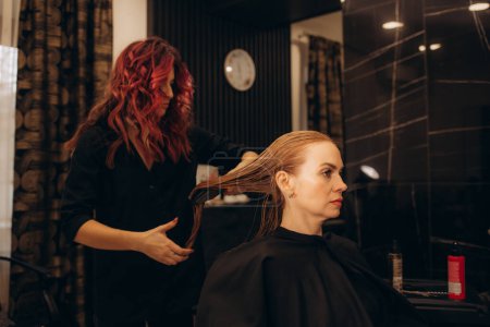 El peluquero podando los cabellos del cliente en el salón de belleza. Foto de alta calidad