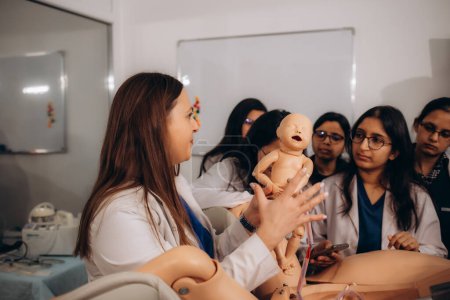 A group of gynecology students performs practical exercises on reproduction of birth processes on a mannequin