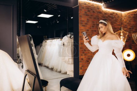 la novia toma una foto de sí misma en el espejo en el salón de bodas