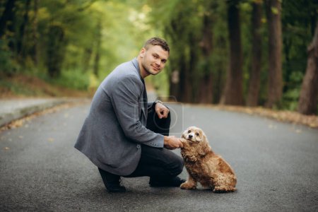 un homme en veste promène un chien