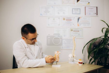 Ortopedista profesional en mesa en consultorio médico. Foto de alta calidad