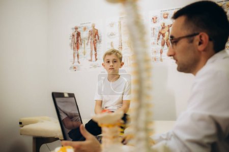 Photo for A male vertebrologist examines a child - Royalty Free Image