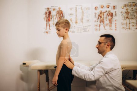 Orthopedist examining child's back in clinic, closeup. Scoliosis treatment. High quality photo
