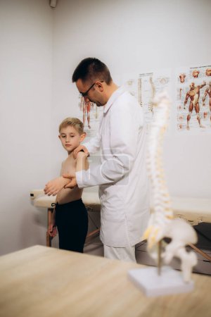 Orthopäde untersucht den Rücken des Kindes in der Klinik, Nahaufnahme. Skoliose-Behandlung. Hochwertiges Foto