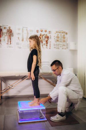 a male vertebrologist examines a girl