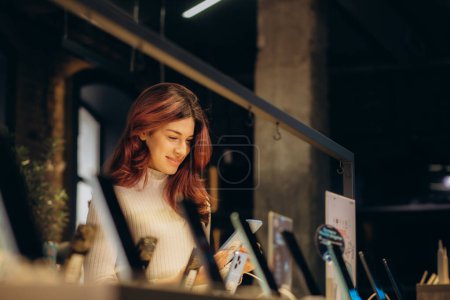 Foto de Una mujer compra un teléfono en una tienda de electrónica - Imagen libre de derechos