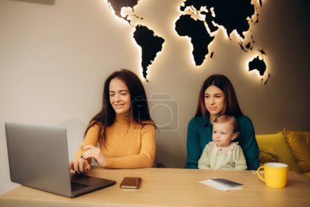 eine junge Mutter kommuniziert mit einem Reiseveranstalter in einem Reisebüro