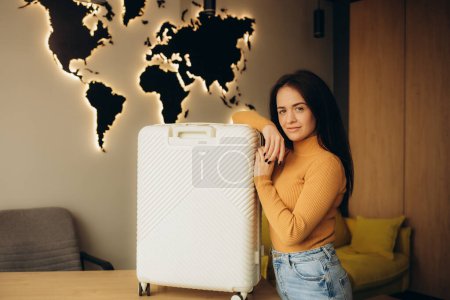 beautiful young woman with a suitcase in a travel agency