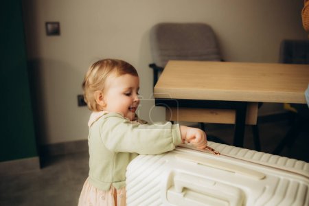 una niña pequeña con una maleta en una agencia de viajes