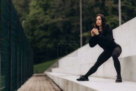 Mujer atlética haciendo empuje inverso hacia arriba en escaleras fitness al aire libre.