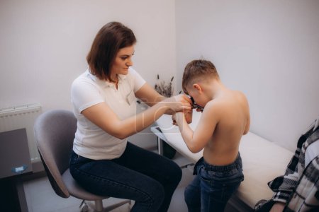 Téléchargez les photos : Gros plan du médecin examinant la peau d'un enfant patient avec dermatoscope - en image libre de droit