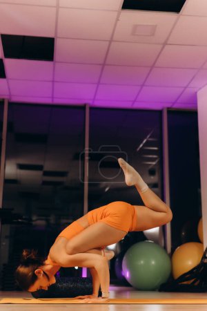 portrait of an athletic woman standing on her hands in the gym