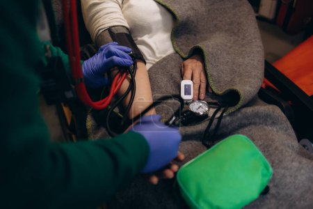 A doctor checks the oxygen level in an ambulance