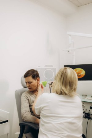 Examen auditif pour les personnes âgées. Otolaryngologue médecin vérifiant l'oreille de la femme mature à l'aide d'un otoscope ou d'un auriscope à la clinique médicale