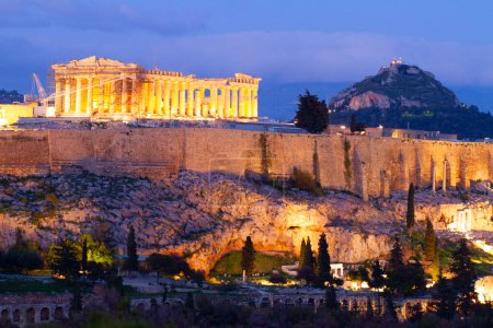 Foto de Famoso horizonte de Atenas con la colina de la Acrópolis y el Pathenon iluminados por la noche, Atenas Greecer - Imagen libre de derechos