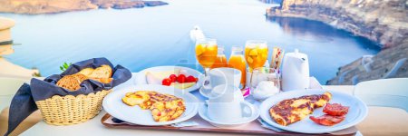 Foto de Desayuno para dos con café, zumo de orabge fresco y yogur por la mañana junto al mar, Grecia, tonificado - Imagen libre de derechos