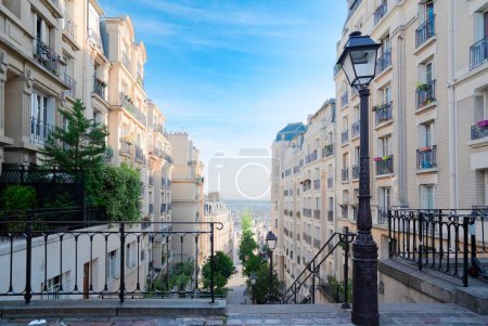 Foto de Vista de la calle con escaleras en el barrio de Montmartre en París, Francia. Acogedor paisaje urbano de París en verano. Arquitectura y monumentos de París, tonificado - Imagen libre de derechos