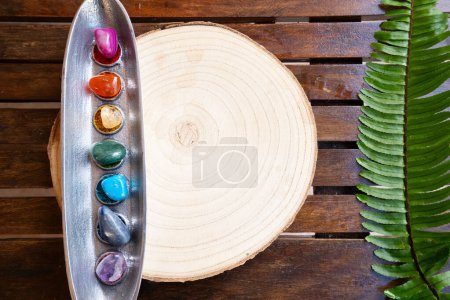 Téléchargez les photos : Sept pierres chakras sur fond en bois, concept de guérison énergétique, espace de copie - en image libre de droit