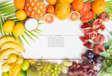Photo for Summer mix of tropical fruits over white wooden background frame with copy space - Royalty Free Image