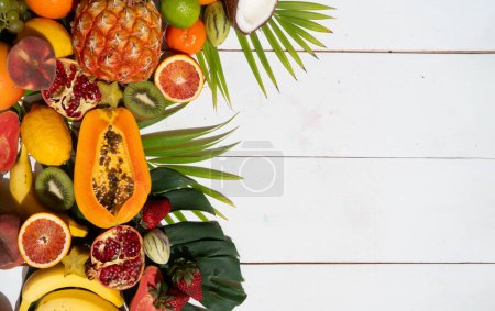 Photo for Summer mix of tropical fruits over white wooden background with copy space - Royalty Free Image