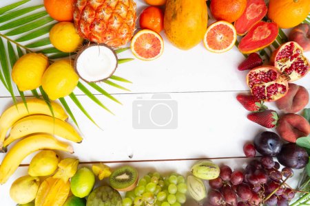 Mélange estival de fruits tropicaux sur cadre en bois blanc avec espace de copie
