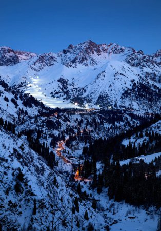 Landschaft der glühenden Straße von Medeu Schlittschuh zu Shymbulak Skigebiet im Tian Shan Gebirge am Abend in Almaty, Kasachstan
