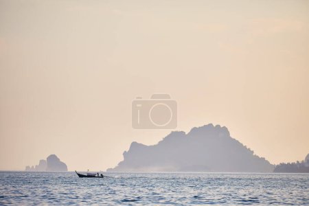 Photo for Traditional long tail in silhouette near tropical islands at sunset in Andaman Sea, Southern Thailand - Royalty Free Image