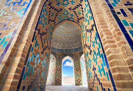 Téléchargez les photos : Belle entrée de l'arche du cimetière historique de Shahi Zinda avec finement décoré par des mausolées en mosaïque de pierre bleue et turquoise à Samarkand, Ouzbékistan. - en image libre de droit