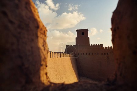 Téléchargez les photos : Coucher de soleil sur les murs de l'ancienne forteresse de Kunya Ark avec tour à Khiva, ville d'Ichan Kala en Ouzbékistan. - en image libre de droit