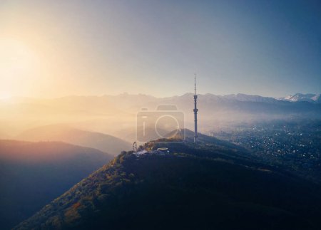 Photo for Aerial drone shot of symbol Almaty city high TV tower and park at Koktobe hill against snow mountains at sunrise in Kazakhstan - Royalty Free Image