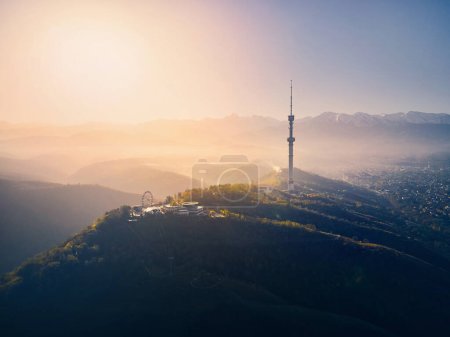 Photo for Aerial drone shot of symbol Almaty city high TV tower and park at Koktobe hill against snow mountains at sunrise in Kazakhstan - Royalty Free Image