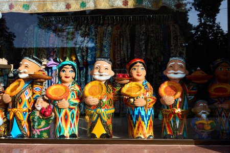 Téléchargez les photos : Figures en céramique de vieillards ouzbeks vêtus de vêtements traditionnels avec du pain rond lepeshka dans une boutique de souvenirs à Samarkand, en Ouzbékistan - en image libre de droit