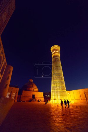 Téléchargez les photos : Place Poi Kalyan la nuit avec minaret Kalyan illuminé et ciel nocturne avec lune à Boukhara, Ouzbékistan - en image libre de droit