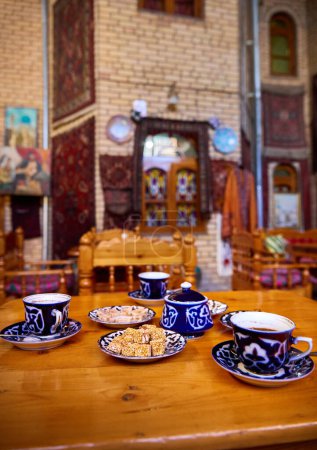 Traditionelle usbekische Teetafel mit Tassen und orientalischen Süßigkeiten im Kaffeehaus in Buchara in Usbekistan, Zentralasien