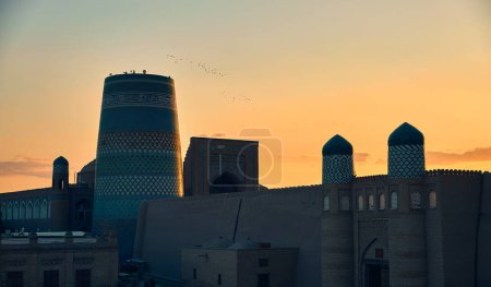 Sonnenuntergang Blick auf das Minarett Kalta Minor und Madrasah von Abdullah Khan von der antiken Stadtmauer in Chiwa in Usbekistan.