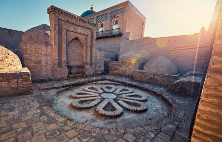 Inner Yard with floor in flower shape from stones near madrasah at ancient city wall at Khiva in Uzbekistan.