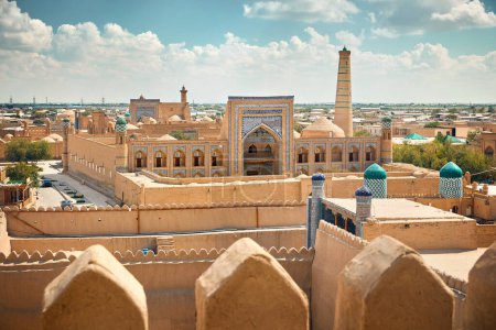 Sunset view of Kalta Minor minaret and Madrasah of Abdullah Khan from fortress roof of ancient city wall at Khiva in Uzbekistan.