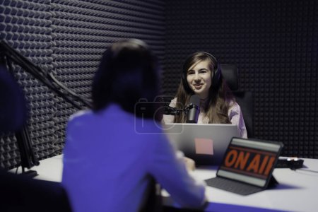 Photo for Two women engage in a lively podcast recording, surrounded by professional soundproofing in a studio - Royalty Free Image