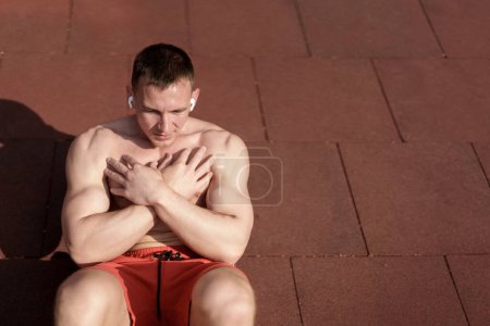 Téléchargez les photos : Homme concentré engagé dans un entraînement abdominal dans un cadre de parc serein, mettant l'accent sur la force de base - en image libre de droit