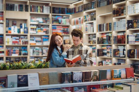 A joyful young couple shares a delightful moment while browsing through books in a well-organized library, surrounded by an extensive collection of literature.