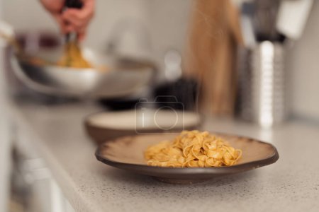 Pasta, die auf einem Teller serviert wird und eine gemütliche, hausgemachte Essensatmosphäre heraufbeschwört