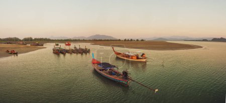Muchos pequeños barcos de pesca en el mar durante el atardecer en Tailandia