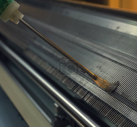 Foto de Máquina automática de tejer con un banco de agujas en el que las prendas se pueden tejer de cerca vista recortada - Imagen libre de derechos