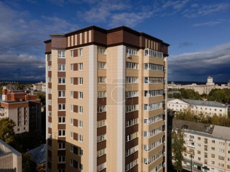 Téléchargez les photos : Extérieur de bâtiments contemporains à plusieurs étages avec fenêtres et arbres verts sous un ciel nuageux bleu en ville - en image libre de droit