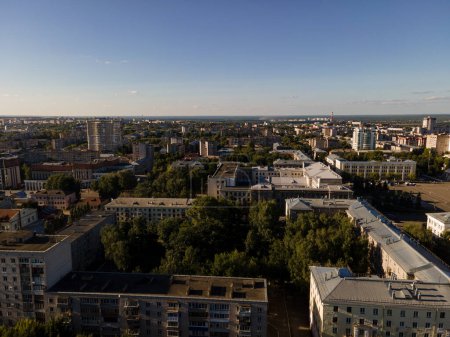 Téléchargez les photos : Vue par drone du quartier de la vieille ville avec des bâtiments résidentiels à plusieurs étages entourés d'arbres verdoyants sous le ciel bleu par une journée ensoleillée - en image libre de droit