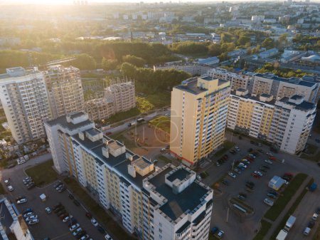 Téléchargez les photos : Vue au-dessus du drone des immeubles d'appartements de grande hauteur situés à proximité de parcs de stationnement avec de nombreuses voitures le matin en ville - en image libre de droit