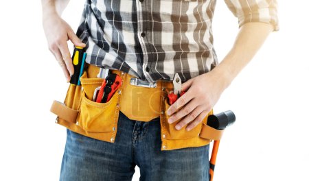 Foto de Man wearing mounting belt with tools for repair isolated on white background. Professional equipment of handyman - Imagen libre de derechos