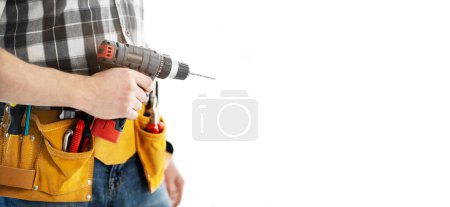 Photo for Man wearing mounting belt with tools for repair holding drill in hands isolated on white background. Professional equipment of handyman - Royalty Free Image